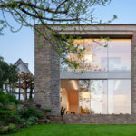 Atelier für Architekturfotografie mit Natursteinmauerwerk und zweigeschossiger Panorama-Glasfassade