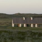 Vipp Ferienhaus in unberührter Landschaft an der dänischen Meeresküste, errichtet aus hochwärmedämmendem, inspiriert von der Form traditioneller Fischerhütten und errichtet aus robustem Porenbeton