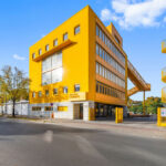 Revitalisiertes gelbes Bürogebäude in Berlin mit gelber Außentreppe von MVRDV