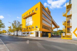 Revitalisiertes gelbes Bürogebäude in Berlin mit gelber Außentreppe von MVRDV