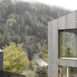 Einfamilienhaus am Hang von Naemas Architekten mit grau lasierter Lärchenholzfassade