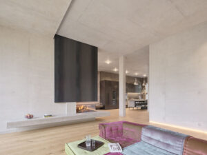 Wohnbereich mit Holzboden und Sichtbetonwänden in Villa M von Delugan Meissl