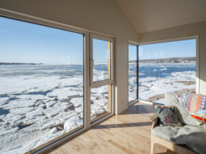 Innenraum in einem Einfamilienhaus mit Blick durch raumhohe Fenster auf Eisschollen