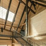 Erschließungshalle mit Treppe und Blick auf die Hochstudkonstruktion im Künstlerhaus Boswil