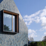 Villa im niederländische Schoorl mit keramischer Fassade aus glasierten Ziegelriemchen in Grau-, Blau- und Grüntonen
