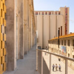 Gelbe Backsteinfassade und Stahlsteg an einem ehemaligen Fabrikgebäude in Lissabon