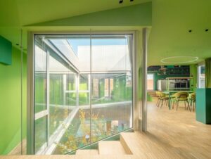 Innenraum eines Wohnhauses mit grüner Decke und grünen Wänden sowie Blick in einen Innenhof