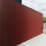 Profilierte Aluminiumfassade in schwedischem Rot für Gartenzimmer plus Garage