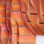 3D-gedruckte Fassadenelemente mit organischer Form und rötlicher Farbe, die an traditionelles Ziegelmauerwerk erinnert