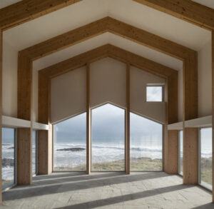 Wohnraum aus Brettschichtholz-Portalrahmen mit Blick aufs Meer