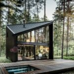 Ferienhaus im Kiefernwald mit schwarzem Aluminiumdach und Terrasse