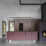 Wohnküche mit farbigen Einbauten und Sichtbetondecke
