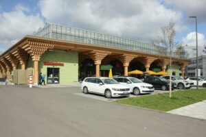 REWE-Supermarkt in Holzbauweise mit urbaner Landwirtschaft auf dem Dach