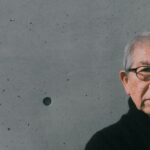 Grauhaariger Mann mit schwarzer Brille vor grauem Hintergrund: Preisträger Riken Yamamoto.
