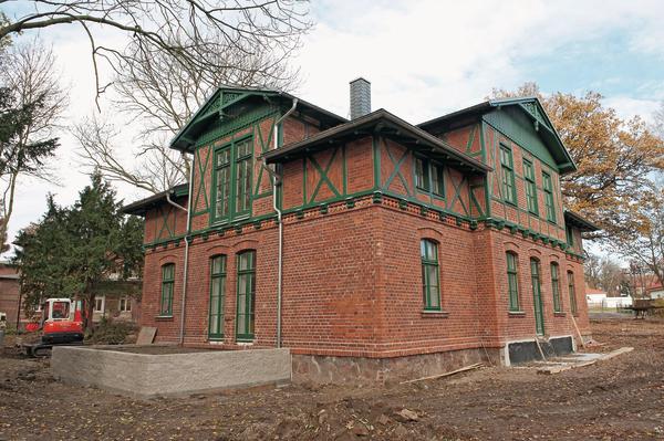 Kompaktes Backsteinhaus mit grün-lackierten Holzdetails. Bilder: URSA