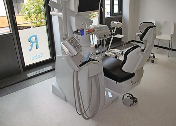 Links neben dem Behandlungsstuhl die aus dem Bodenhohlraum angesteuerte Behandlungseinheit in einer Zahnarztpraxis.