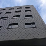 Fassade aus schwarzen Metallschindeln.