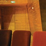Brandschutztür aus Holz mit an die Wandgestaltung angepasstem Deckfurnier in einem Konzertsaal. Bild: Lindner