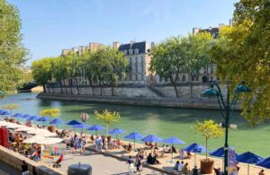 Grüner Stadtstrand mit blauen Sonnenschirmen am Pariser Seine-Ufe