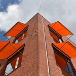 Textiler sommerlicher Wärmeschutz in Orange an Backsteingebäude