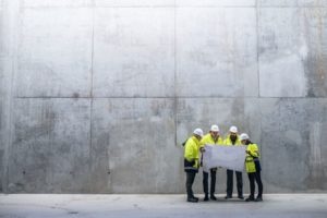 Ingenieure vor einer Betonwand