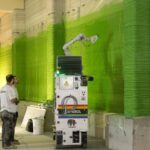 Roboter führt Malerarbeiten aus und beschicktet 3D-gedruckte Innenwand mit grüner Farbe