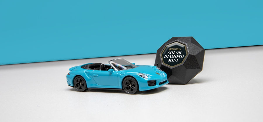 Farbton-Scanner Color Diamond mini neben himmelblauem Spielzeug-Porsche-Cabrio