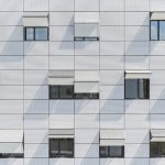 Mehrgeschossiges Gebäude mit weißen Fassadenplatten bei Tag. Bild: Colt International GmbH