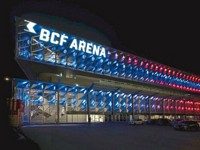 Eishockeystadion in Fribourg mit farbig beleuchteter Fassade aus dreidimensionalen, perforierten Aluminiumelementen