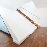 Viel Weiß und Designböden mit Holzdekor tragen im Inneren zum harmonischen Gesamteindruck bei. Bild: Architekten Spiekermann
