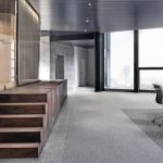 Büro mit grauem Teppichboden und Holzstufen. Bild: Tarkett