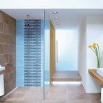 Modernes Bad mit ebenerdiger Dusche, großen Bodenfließen und beleuchteter Stufe vor der Eingangstür. Bild: Deutsche Steinzeug