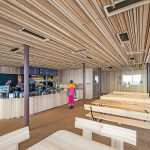 Der Innenausbau mit Holz verweist auf alpine Traditionen. Das Holzrelief an der Decke dient gleichzeitig der Akustik. Bild: HeidelbergCement AG/Steffen Fuchs