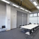 Rahmenlos montierte Holzwolleplatten auf der massiven und schallharten Wand verbessern die Raumakustik und unterstreichen das technisch-funktionale Ambiente. Bild: Knauf AMF