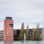 Der denkmalgeschützte, vollständig kernsanierte ehemalige Flughafen-Tower ist markanter Teil des neuen Gebäudekomplexes in München-Riem. Bild: Lindner Group