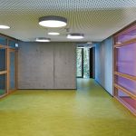 Der grüne Bodenbelag kennzeichnet die multifunktionale Fläche, die Treppenhaus und Gruppenräume verbindet. Bild: Christian Eblenkamp