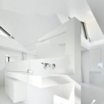 Die von Spiekermann entworfenen, ganz in Weiß gehaltenen Sanitärobjekte zonieren den Raum. Bild: Architekten Spiekermann
