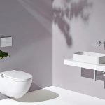 Modernes Badezimmerensemble mit Toilette und Waschbecken. Bild: Laufen