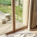 Faltbare Fensterfront mit schmalen Holzprofilen, farblich an den Boden angepasst. Blick zum Garten und Terasse. Bild: Solarlux