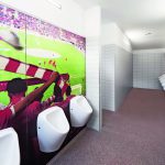 Die Sanitärbereiche des Düsseldorfer Fußballstadions wurden mit farbig bedruckten Motivwänden und WC-Kabinen in den Vereinsfarben neu gestaltet. Bilder: Schäfer Trennwandsysteme