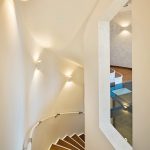 Elegantes Treppenhaus im Farbton Creme, kombiniert mit warmen Holztönen. Bild: Mathieu Ducros