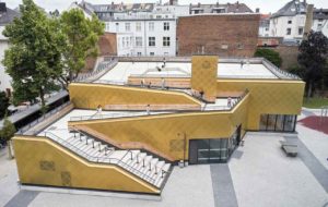 Schulsporthalle von Trapez Architektur mit goldfarbener Kupferfassade in Frankfurt-Sachsenhausen